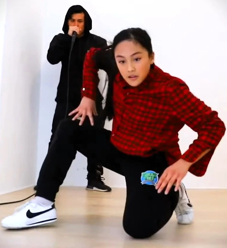 Logan Edra breakdancing in a studio with another person in the background