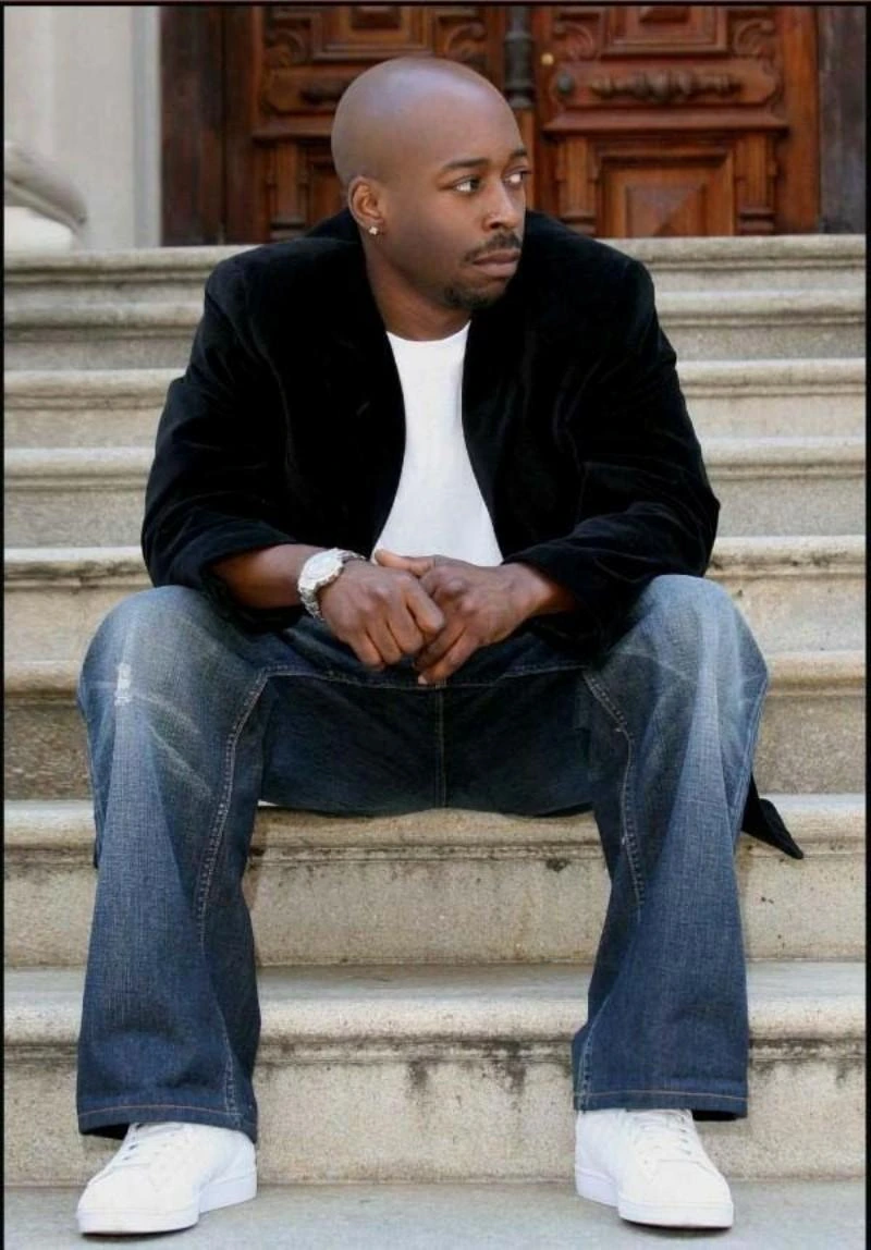Portrait photo of Smoothe Da Hustler sitting on steps